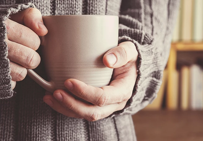 Hand mit Kaffee Koffeinverzicht bei Kopfschmerzen