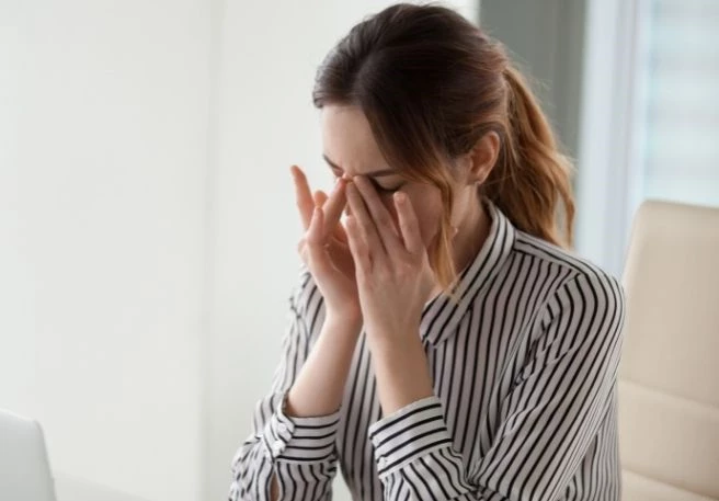 Frau hält Hände vor die Augen Bei Augenzucken kann Magnesium helfen