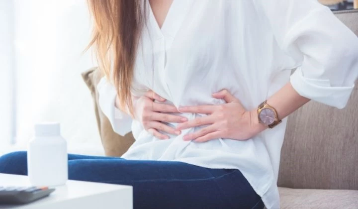 Frau mit Blähungen Mögliche Magnesium Nebenwirkungen sind Blähungen